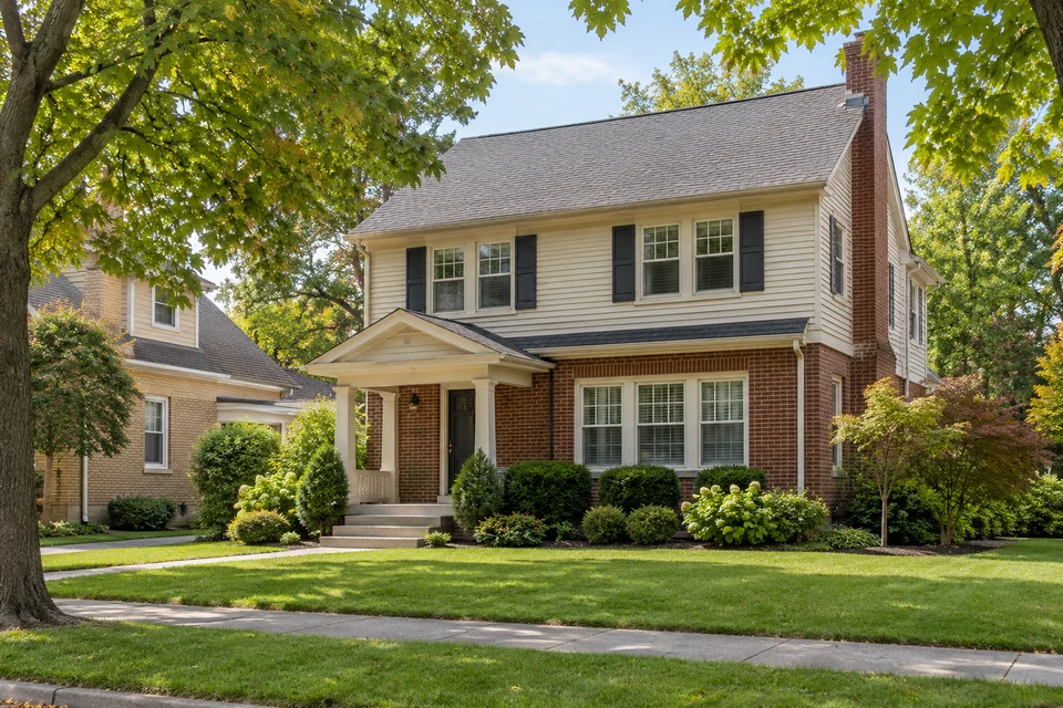 A well-kept Michigan home beside a green, tree-lined street.